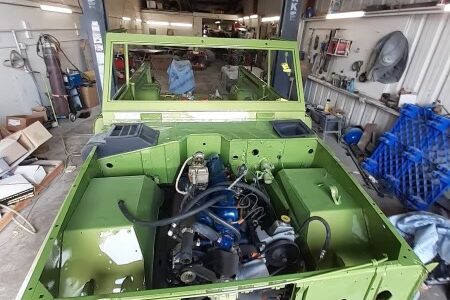 A green truck with a blue engine in it.