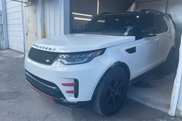 A white land rover parked in front of a building.