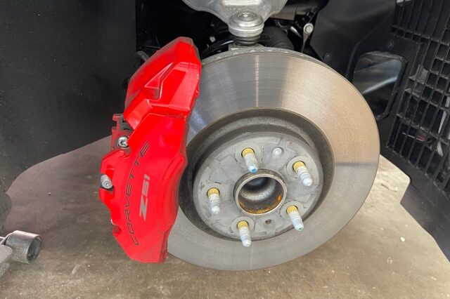 A red brake caliper and disc are on the ground.