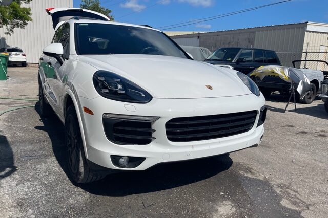 A white car parked in the lot with other cars.